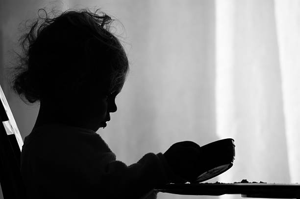 Hunger (XL) A two year old girl is sadly looking into her empty bowl wishing she had more to eat. hungry stock pictures, royalty-free photos & images