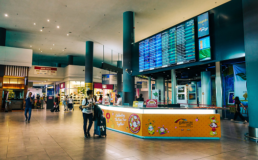 Duty-free store is a retail store located in Munich airports, that offers tax and duty-free goods to international travelers who are leaving or entering the country and typically include products such as alcohol, tobacco, perfume, cosmetics, electronics, and luxury items such as jewelry and watches. A few person shopping inside.