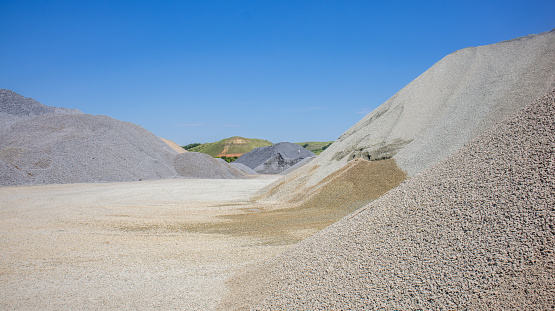 Asphalt concrete mixes, mineral materials. Pile of gravel, crushed stone, sand, mineral powder and building material for the production of asphalt. Territory of the asphalt concrete plant.
