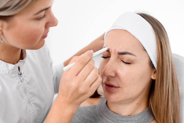 istock beautician accurate makes marks on female face for botox injection procedure. 1473001687