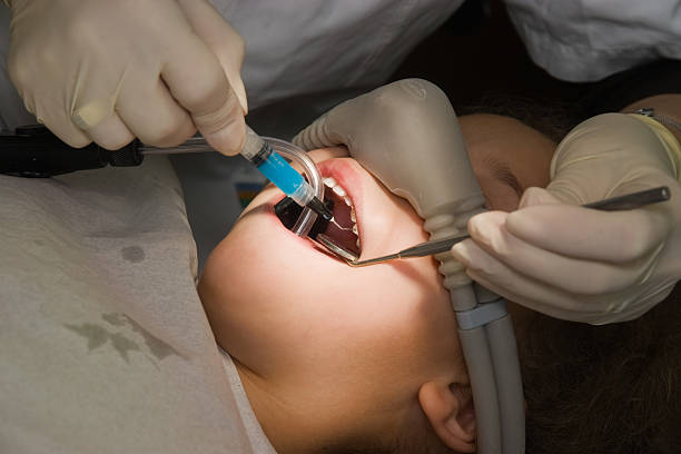 dentist performs a procedure of care for teeth child