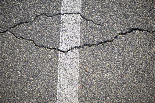 texture of white paint for road marking on asphalt, texture of painted asphalt cracked texture white background, white background on gray asphalt, pedestrian crossing, new road marking close up