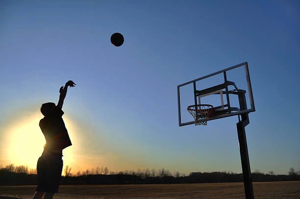 sagoma di teen ragazzo di basket di tiro - jump shot foto e immagini stock