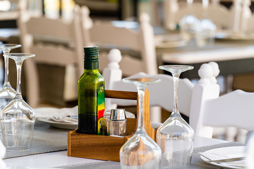 Bottle with olive oil on the table without people in a restaurant