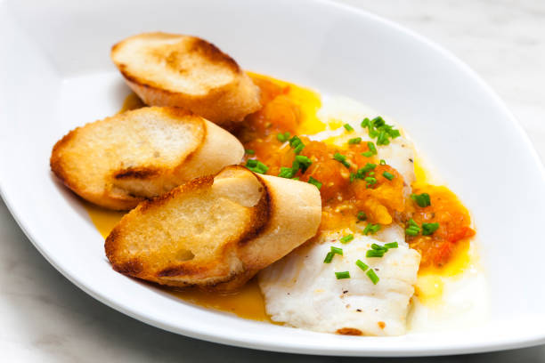 istock white fish with tomato sauce and roasted baguette slices 1473009548