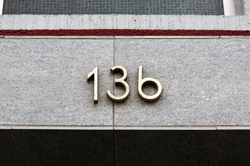 Metal house number on stone wall