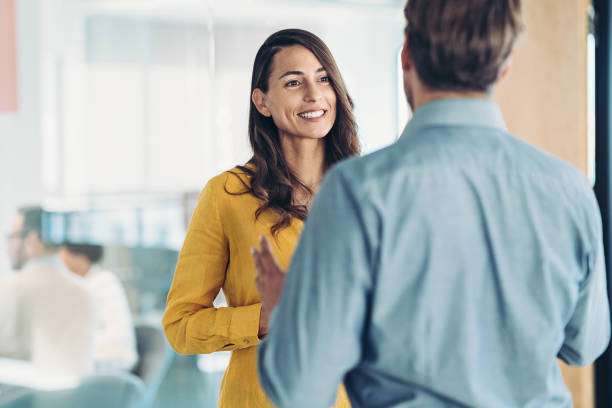 istock Smiling businesswoman having a conversation with a coworker 1473011471