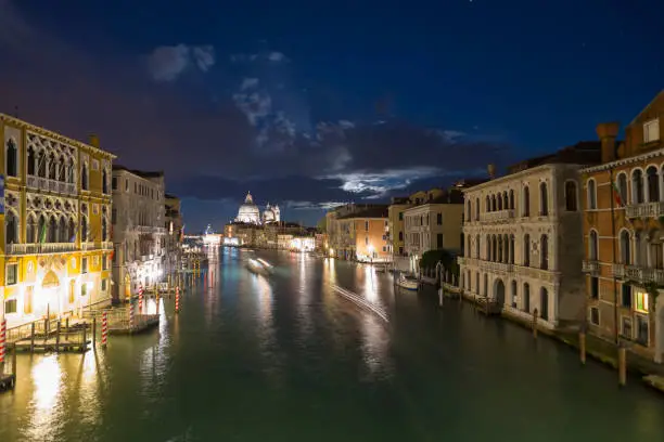 View from the Accademia Bridge over the Grand Canal and the Basilica Santa Maria della Salute in Venice at a full moon night