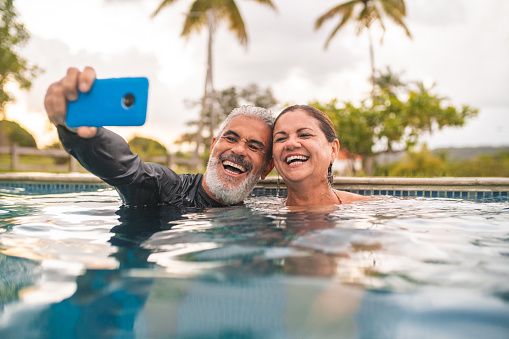 Well being of mature couple taking a selfie in the pool
