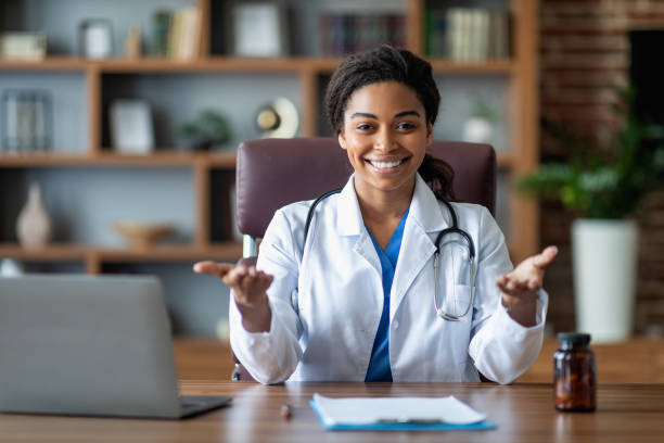 istock Doctor black woman in white robe with stethoscope at workplace 1473015823