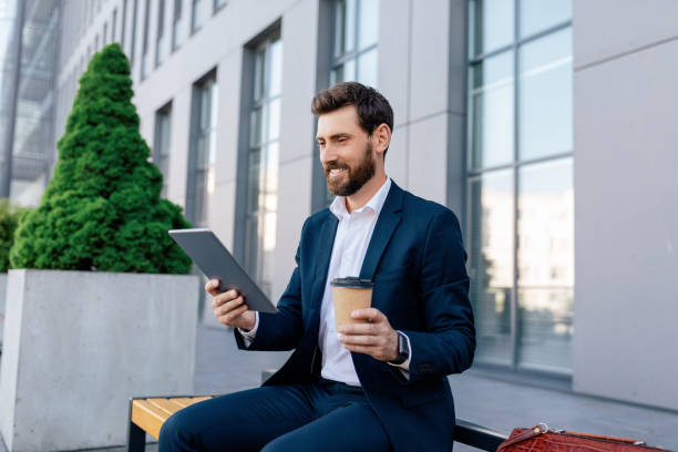 istock Coffee break, successful business. Glad confident attractive young caucasian guy with beard in suit 1473016660