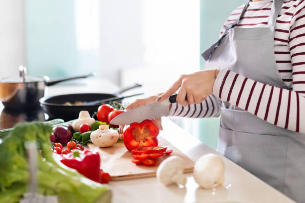 istock Unrecognizable woman cutting fresh vegetables, preparing meal at home 1473017289