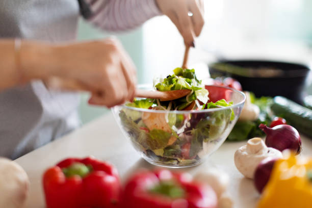 istock Female hands making fresh vegetable salad, preparing meal at home 1473017408