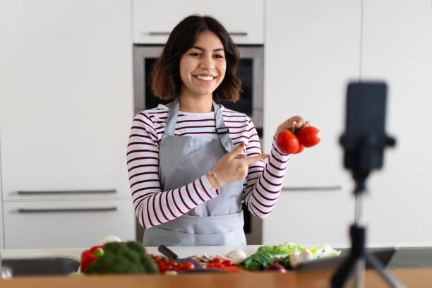istock Pretty young woman influencer streaming while cooking at home 1473017422