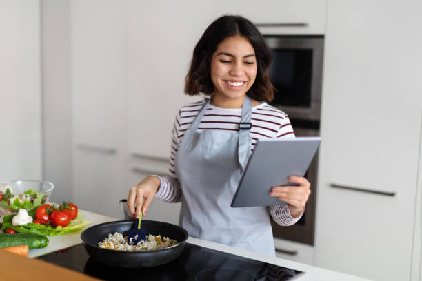 istock Happy brunette woman enjoying cooking at home, using digital tablet 1473017459