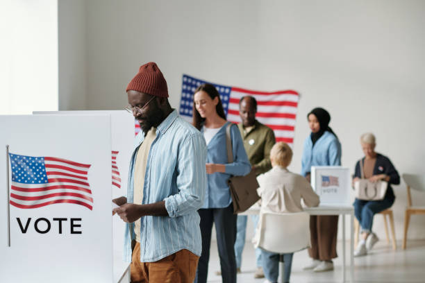 Group of young multicultural voters standing in queue in polling place stock photo
