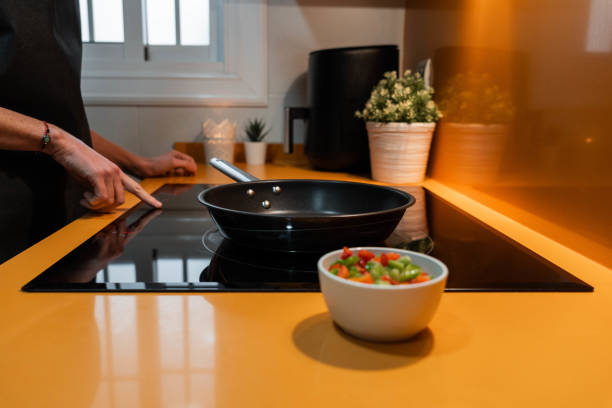 istock Unrecognizable person switching the induction in orange kitchen 1473018643