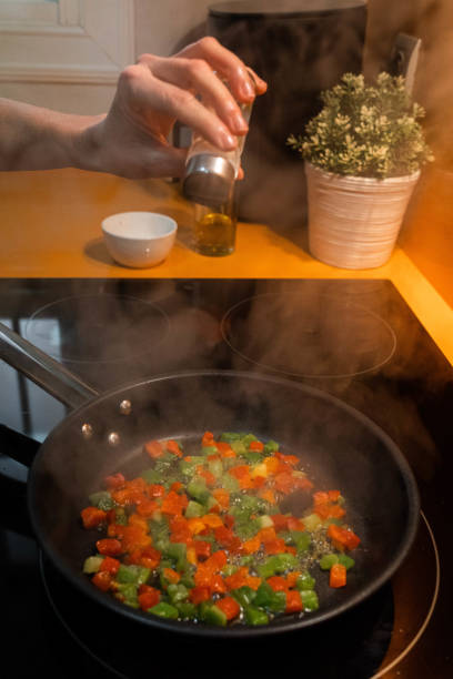 istock Unrecognizable hand throwing salt and cooking vegetables in a frying pan 1473018652