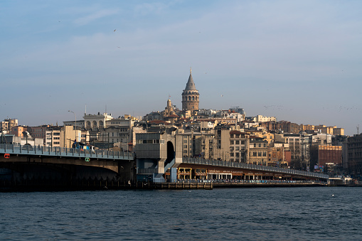 Istanbul, Turkey, 02/25/2023: View of Beyoglu district with Galata Tower and Galata Bridge in the foreground from the waters of the Golden Horn Bay on a sunny day