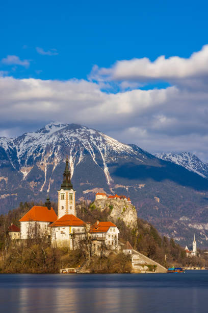 bleder see mit bleder katze, kirche und winter julische alpen im hintergrund - castle slovenia winter snow stock-fotos und bilder