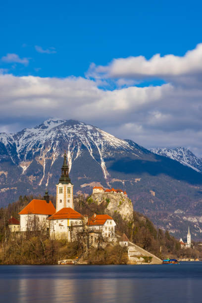 lago de bled con ganado de bled, iglesia y alpes julianos de invierno al fondo - castle slovenia winter snow fotografías e imágenes de stock