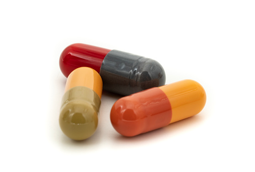 Red and yellow capsules on white background.