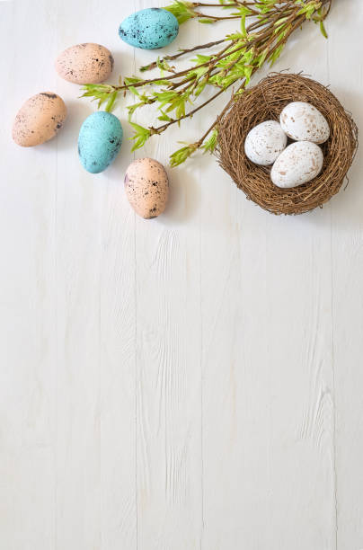 istock Branches with green leaves and easter eggs on a light background. Happy easter flat lay concept 1473023445