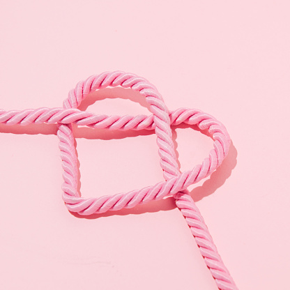Heart shape rope knot, creative aesthetic romantic candy pink love concept.