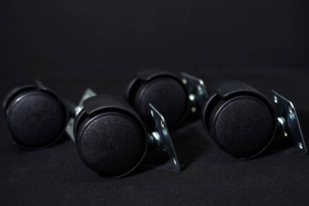 istock Black plastic furniture rollers on a black background. 1473024518