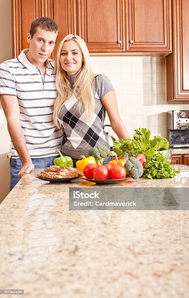 Pareja joven posando en la cocina - Foto de stock de 20 a 29 años libre de derechos