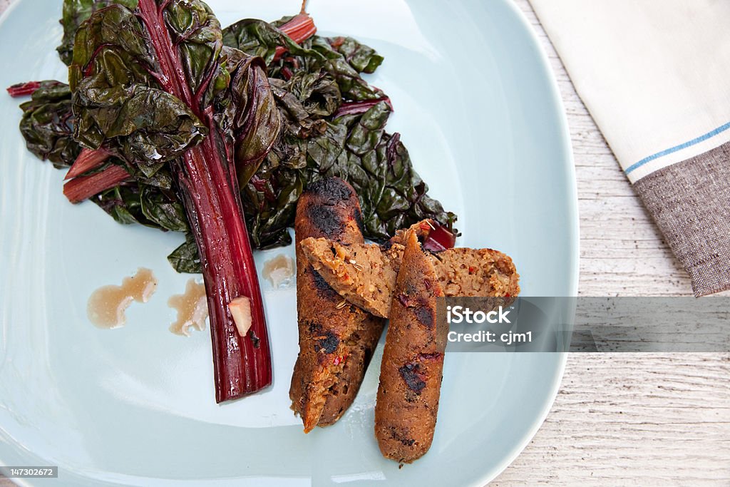Organic Swiss Chard and Grilled Vegetarian Sausage a plate of swiss chard with vegetarian sausage links Food Stock Photo