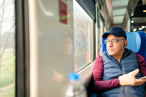 istock Senior man traveling in train and using a smartphone while enjoying the view. 1473031179