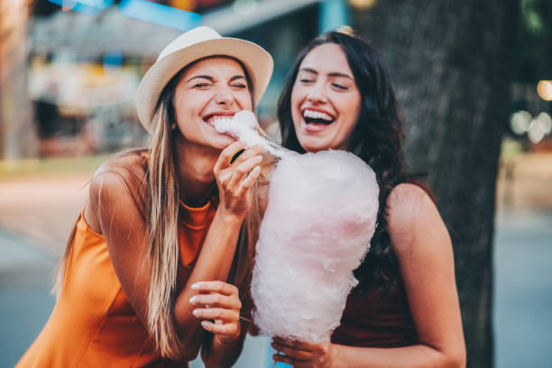 glückliche frauen im freizeitpark - people eating walking fun stock-fotos und bilder