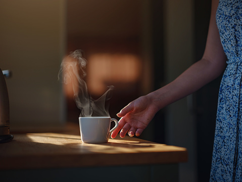 Woman is drinking coffee , morning routine. Tiny house. First property. Small apartment interior design. Minimalism. Moving in. Living alone. Charming trailer house with the morning sun