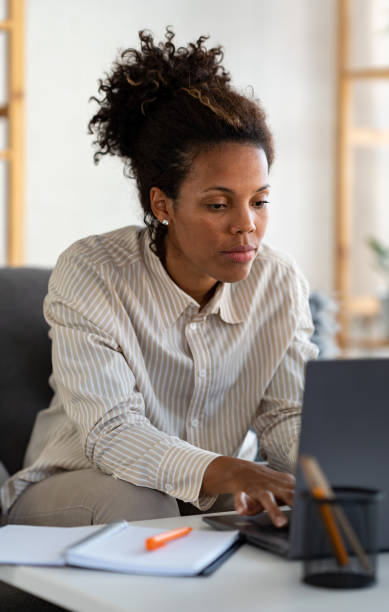istock Young African ethnicity businesswoman working from home using a laptop computer 1473033749