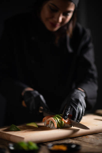 istock Female sushi chef making roll sushi 1473033891