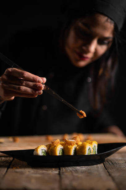 istock Female sushi chef making roll sushi 1473034744