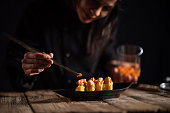 Female sushi chef making roll sushi