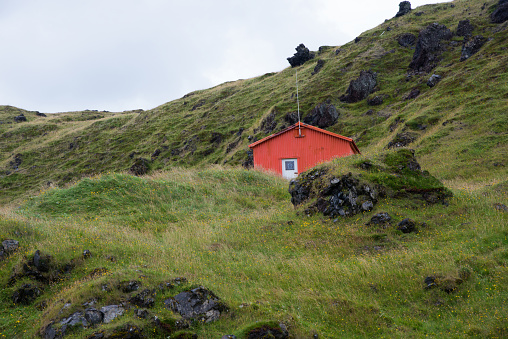 Beautiful landscape with green hill and small wooden hut. Snafelness, Iceland