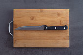 Cutting board and knife on a grey kitchen countertop