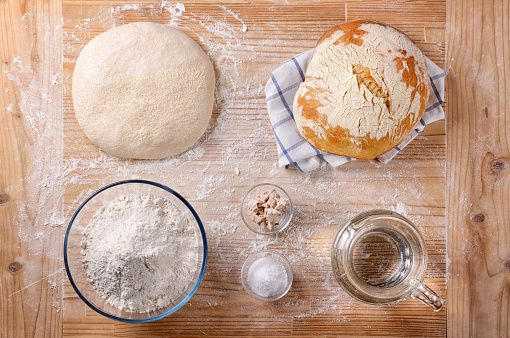 The ingredients, the dough and the freshly baked bread, flat lay.