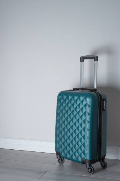 istock Green wheel suitcase in light room interior 1473039282