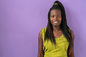 istock Portrait of smiling Afro american women standing in front of purple background 1473040115