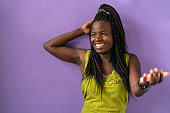 istock Portrait of smiling Afro american women standing in front of purple background 1473040117