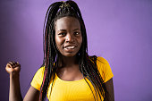 istock Portrait of smiling Afro american women standing in front of purple background 1473040125