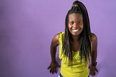 istock Portrait of smiling Afro american women standing in front of purple background 1473040127