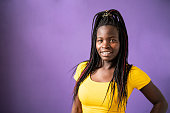 istock Portrait of smiling Afro american women standing in front of purple background 1473040132