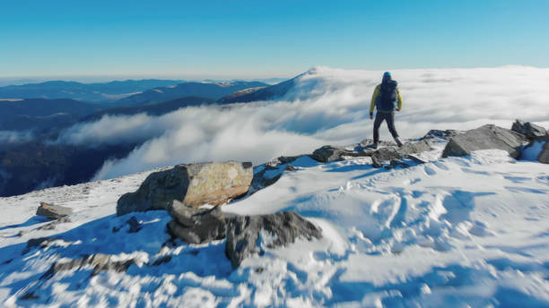 istock Backpacker hikes snowy mountain ridge above valley 1473043478
