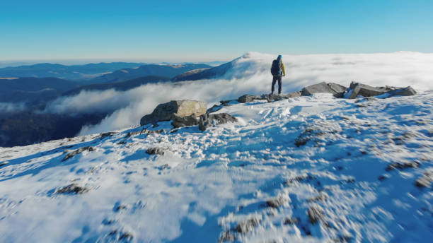 istock Backpacker hikes snowy mountain ridge above valley 1473043479