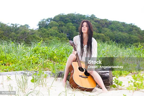 魅力的な若い女性屋外でギター - 人里離れたのストックフォトや画像を多数ご用意 - 人里離れた, 流木, 浜辺